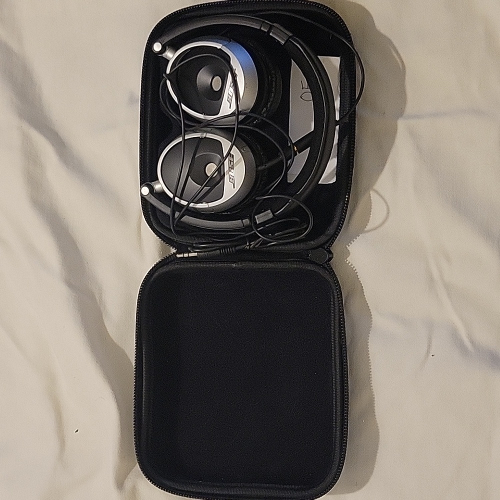 Bose Canceling Noise Headsets To Fix. Silver and Black Headphones with Case